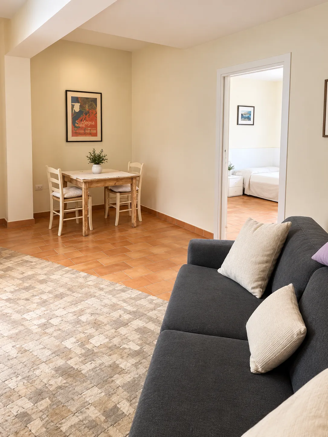 Soggiorno della camera Bellavista 25 con divano letto e tavolo, Bellavista Rooms Villasimius