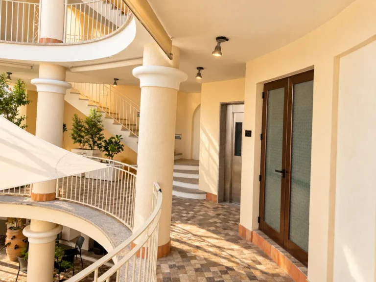 Atrio con scala, balconate curve e ascensore, Bellavista Rooms Villasimius